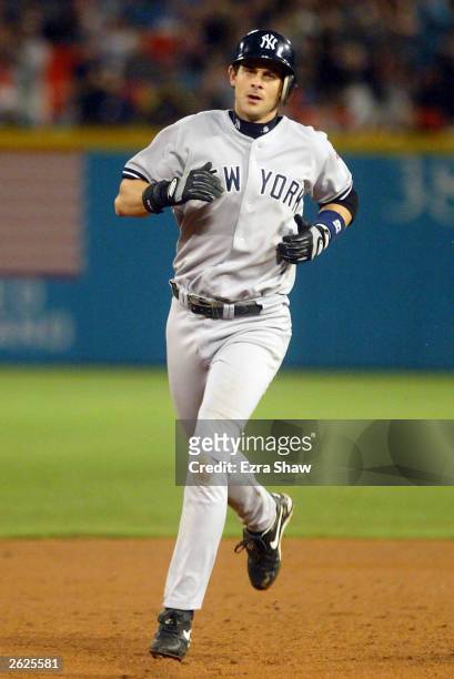 Aaron Boone of the New York Yankees circle the bases after hitting a home run in the ninth inning against the Florida Marlins during Game 3 of the...