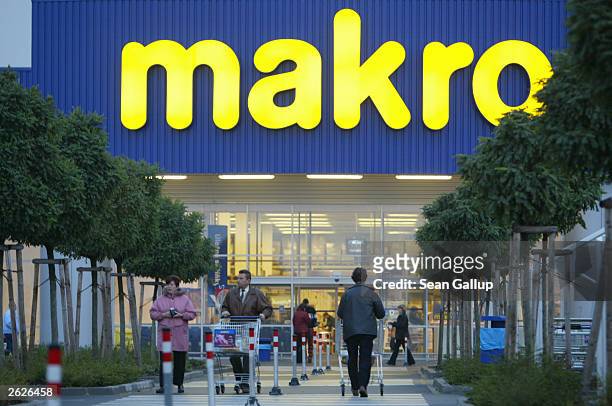 Shoppers enter and leave a Makro discount supermarket and retailer October 21, 2003 in Pilsen, Czech Republic. Makro is a subsidiary of Metro AG of...