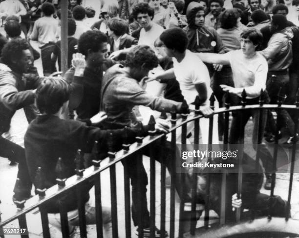 Black and white youths clash with police in Toxteth, Liverpool, during an anti-police demonstration. A fallen policeman tries to regain his feet as...