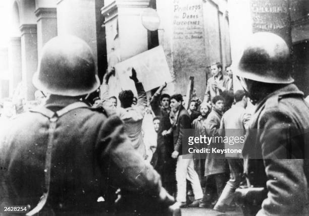 Muslim supporters of the National Liberation Front demonstrate in the Casbah, Algiers, in front of a cordon of French troops.