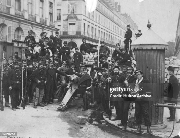 National guardsmen pose in front of an artillery barricade in the Place Vendome, during the civil war between the Third Republic and the Paris...