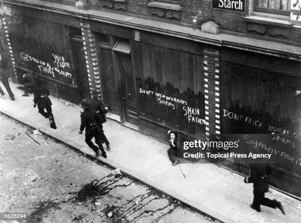 Policemen chasing Communist counter-demonstrators at a Fascist demonstration near Mark Lane, London.