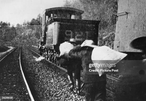 Men carrying sacks in a scene from the film 'The Great Train Robbery', directed by Edwin S Porter for Edison Manufacturing Company. Original...