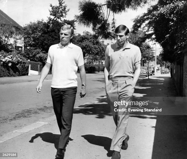 West Ham United and England football players Bobby Moore and Martin Peters taking a walk along a suburban street. Original Publication: People Disc -...