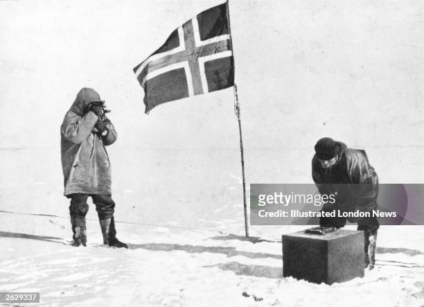 Norwegian explorer Captain Roald Amundsen taking sights at the South Pole, beside the Norwegian flag.