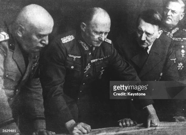German Chief of Staff General Alfred Jodl with Adolf Hitler, Benito Mussolini, and General Keitel planning dispositions. Original Publication: People...