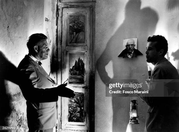 American sexologist Alfred Kinsey and film-maker Kenneth Anger examining some of Aleister Crowley's murals at his Abbey at Cofalu, Sicily. Original...