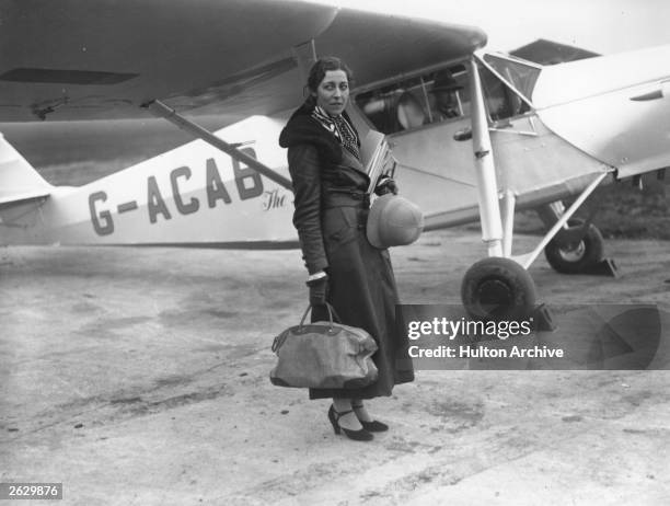 English aviatrix Amy Johnson stands in front of her aircraft at Stag Lane Aerodrome, before setting out on her record-breaking flight to South Africa...