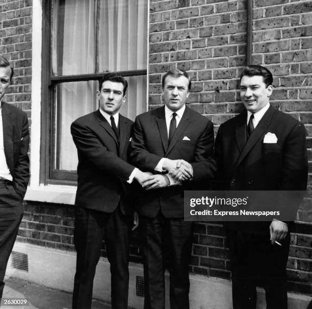 London gangster twins Ronald and Reginald Kray link hands with their brother Charles after the twins had been found not guilty on a menaces charge....