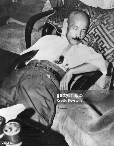 General Hideki Tojo , former premier of Japan, sprawling in a chair with a self-inflicted gunshot wound to the chest. He had attempted suicide to...