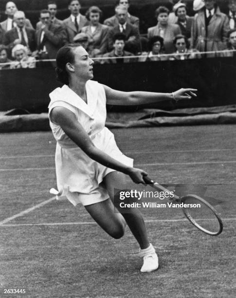 American tennis player Gertrude 'Gussie' Moran in action on the wet number three court at Wimbledon.