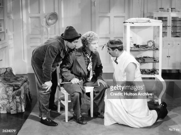 Chico Marx , Harpo Marx and Groucho Marx star in the film 'A Day at the Races', directed by Sam Wood and produced by MGM.
