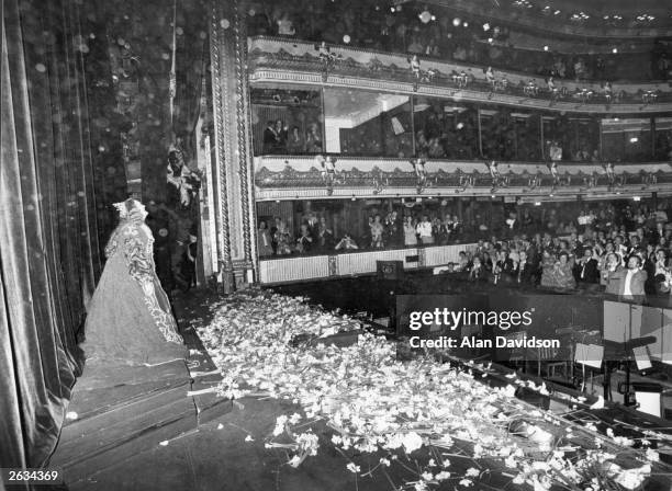 Dame Joan Sutherland, the Australian soprano singer, being showered with flowers on stage at Covent Garden.