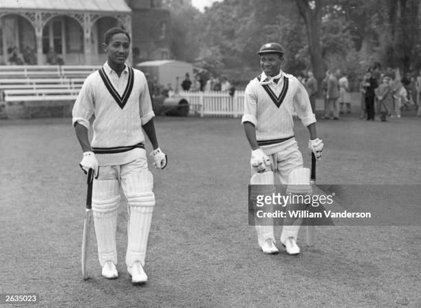 West Indian cricketers Frank Worrell and Everton Weekes heading out to bat against Cambridge University. Original Publication: Picture Post - 5056 -...