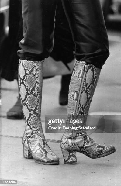 Knee-length fashion boots in a patterned design - legs only visible.