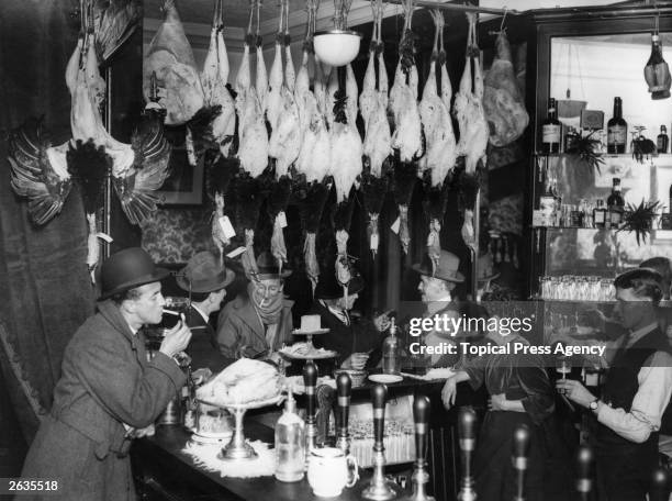 City bar in London at Christmas with plucked turkeys hanging overhead.