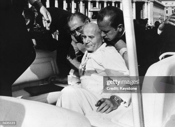 Pope John Paul II being supported by his aides moments after the assassination attempt by a Turkish terrorist in St Peter's Square, Rome.