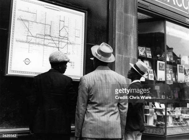 Group of Jamaican immigrants new to London scrutinise a map of the Underground, July 1948.