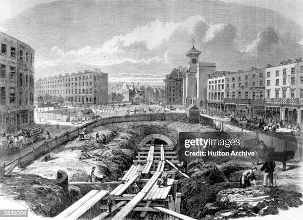 Workmen make progress on the Metropolitan Line underground railway works at King's Cross. They are fenced in from the pedestrians and others going...