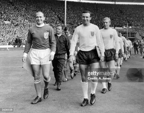 Leeds United footballer Jimmy Armfield leads out the England team as captain, as Alfredo Di Stefano leads out the Rest Of The World Team. They are...
