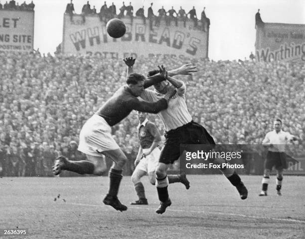 Butler, the goalkeeper for Portsmouth FC, and McDonald, the Fulham FC centre-forward, struggle for the ball during a 1st division FA league match at...
