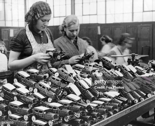 Staff in a toy factory in Walthamstow, London, cleaning a mass of cars before they are packed.