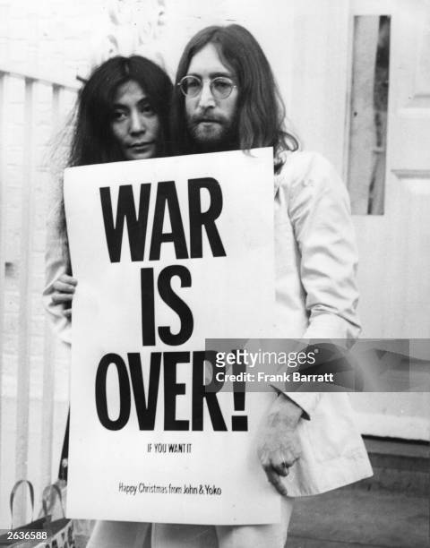 John Lennon and Yoko Ono pose on the steps of the Apple building in London, holding one of the posters that they distributed to the world's major...