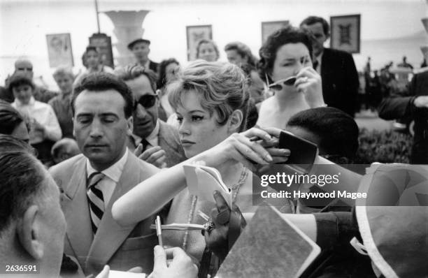 French actress Brigitte Bardot is besieged by fans and autograph hunters at the Cannes Film Festival. Original Publication: Picture Post - 8378 -...