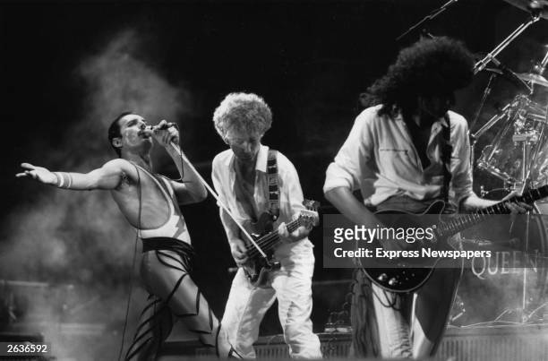 British rock group Queen in concert, from left to right; Freddie Mercury , John Deacon, and Brian May. Original Publication: People Disc - HU0463