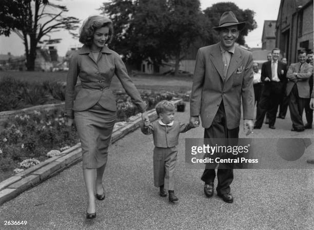 Film star Humphrey De Forest Bogart and his fourth wife Lauren Bacall walk their son Stevie through the grounds of Isleworth film studios, where he...