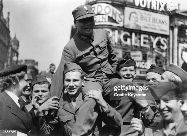 Member of the Chinese Military Mission in London, passing through Piccadilly Circus, was carried shoulder high by crowds singing 'For He's A Jolly...