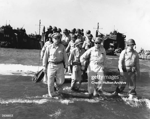 General Douglas MacArthur , wearing sunglasses and leading his troops ashore in the Lingayen Gulf in the Philippines, fullfilling his promise to...