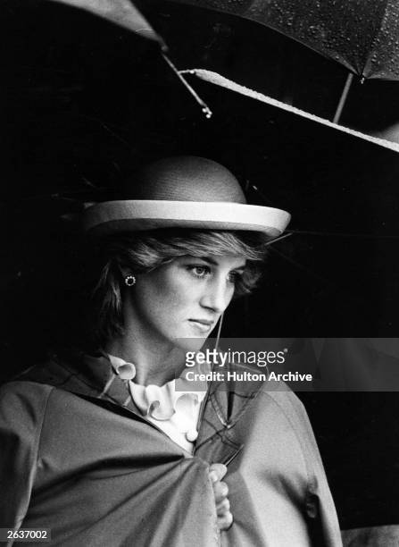 Lady Diana Spencer , future Princess of Wales sheltering under an umbrella.