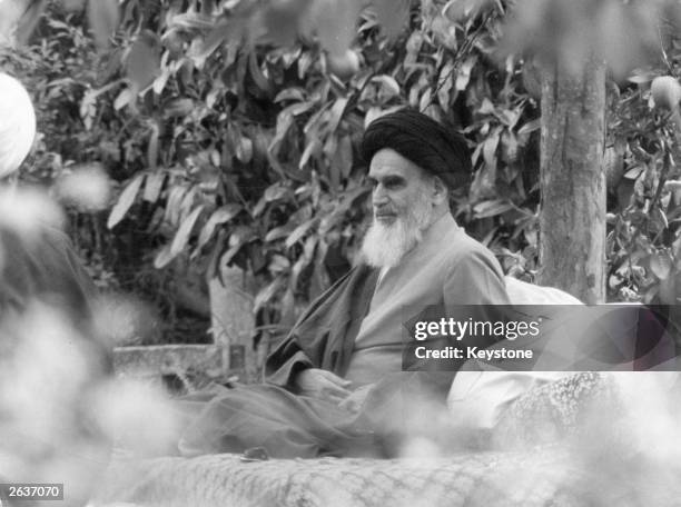 Ayatollah Ruhollah Khomeini , Iranian Shiite religious and political revolutionary leader, sits in a garden in Pontchartrais, on the outskirts of...