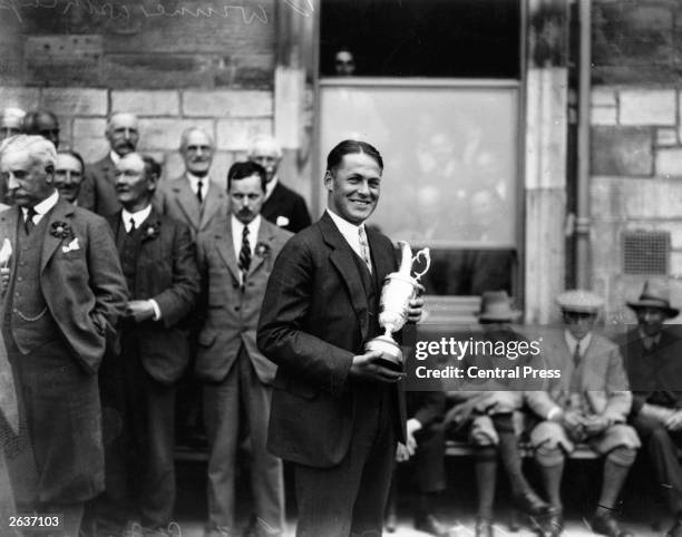 American golfer Bobby Jones holding the trophy after winning the 1927 Open Golf Championship at St Andrews. Jones won the British Open three times...