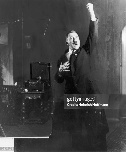 Adolf Hitler , leader of the National Socialist German Workers' Party , strikes a pose for photographer Heinrich Hoffmann whilst listening to a...