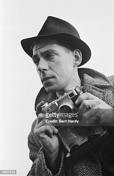 Picture Post photographer Bert Hardy on an assignment, February 1941. He is using a Contax II 35 mm rangefinder camera. Original Publication: Picture...