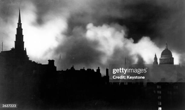 Fires burning in central London after Luftwaffe air raids during the blitz, December 1940. The dome of St Paul's Cathedral is on the right.