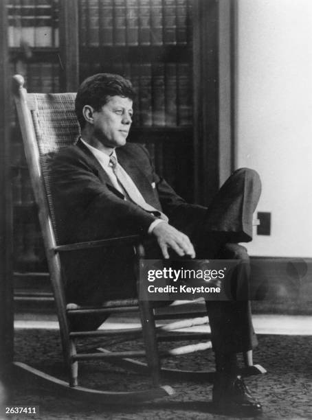 John Fitzgerald Kennedy , the American president sitting in a rocking chair.