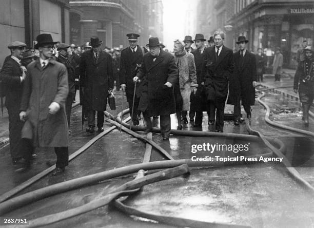 Sir Winston Leonard Spencer Churchill , British politician, touring the blitz damaged streets in the City of London. He is accompanied by his wife...