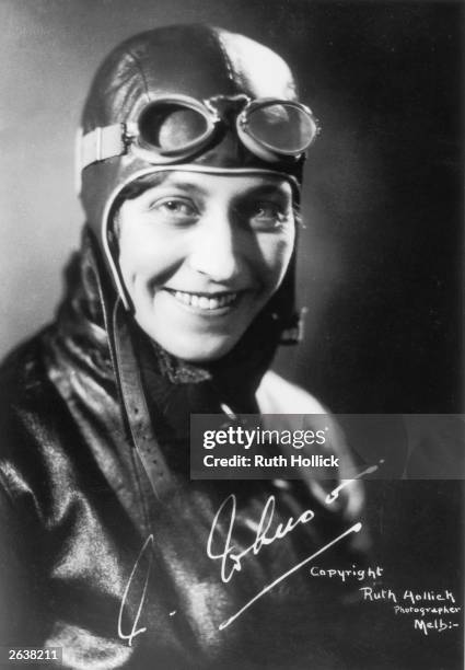 Amy Johnson the English pioneer aviator, later married to Captain Jim Mollison, in her aviators costume, with her signature.