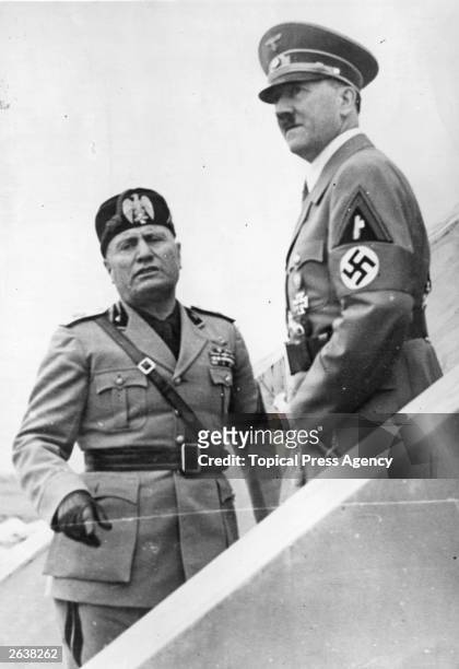 Italian dictator Benito Mussolini with German dictator Adolf Hitler watching a military display being held at the Camp of Cento Celli. Original...