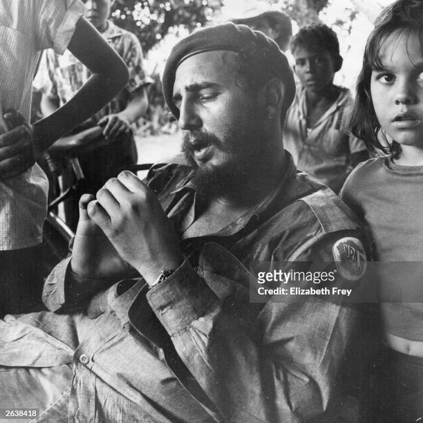 Cuban revolutionary leader Fidel Castro relaxing at a sugar plantation near Havana, surrounded by children. Original Publication: People Disc - HC0495
