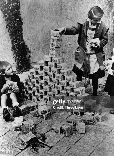 Children using notes of money as building blocks during the 1923 German inflation crisis.