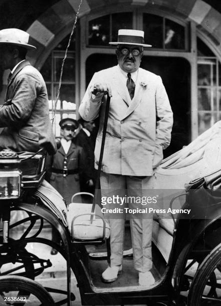 The Aga Khan III , at Deauville standing up in a open carriage.
