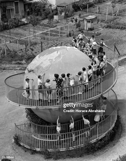 Pupils at a school in Paris learning their geography from a giant globe in the playground.