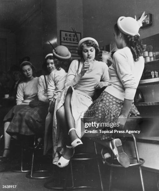 Teenagers drinking milkshakes in a milk bar. Original Publication: Picture Post - 5407 - Sex And The Citizen - pub. 1950