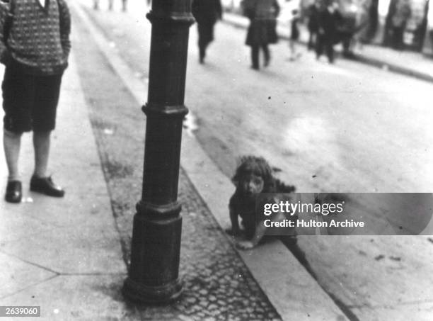 Small child playing in the gutter on the streets of Berlin.