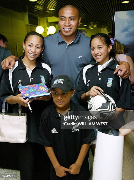 New Zealand All Black number eight Jerry Collins poses with young fans upon the team's arrival at Brisbane Airport 23 October 2003. The All Blacks...