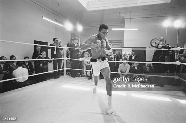 American heavyweight boxer Muhammad Ali throws bare-handed punches in the ring while in training for his fight against Brian London, London, England,...